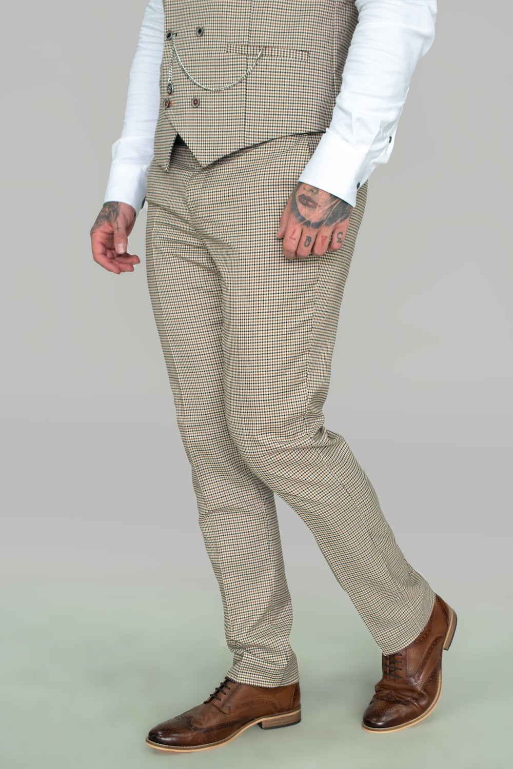man in houndthooth checked beige trousers and brown shoes